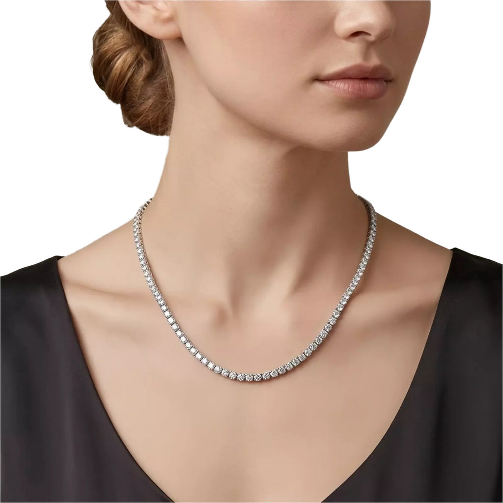 A close-up of a woman's neck and chest wearing a diamond necklace.