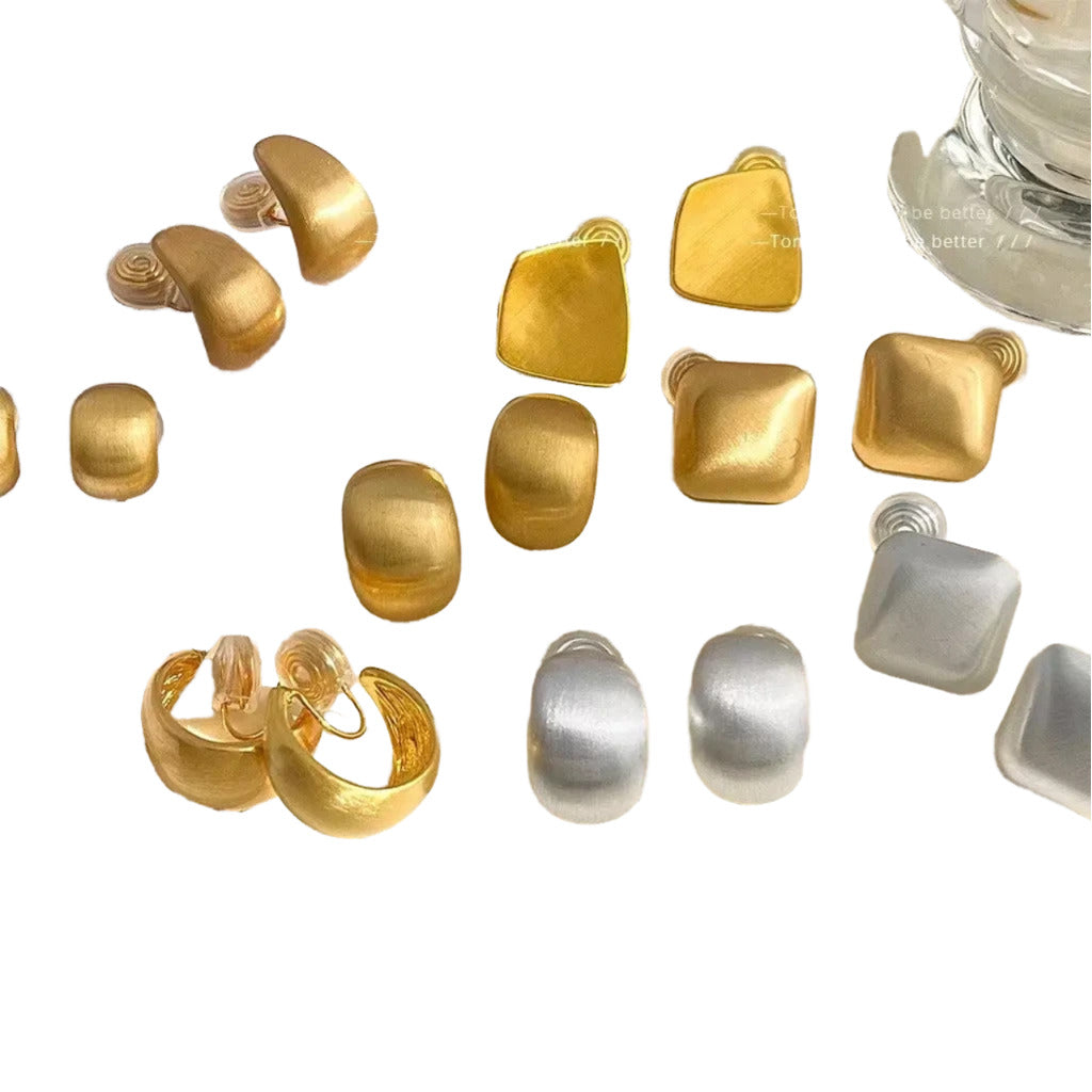 a variety of gold and silver earrings and earring backs arranged on a white background.